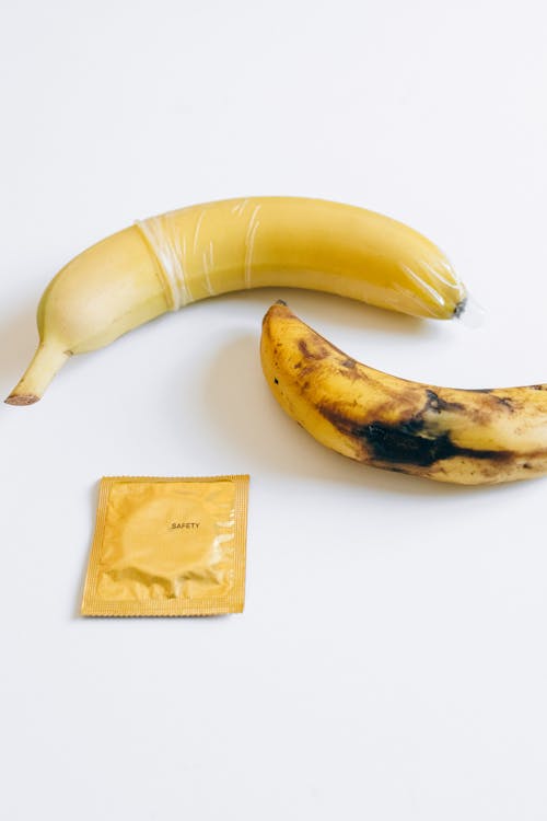 Free Condom Next to Bananas Stock Photo