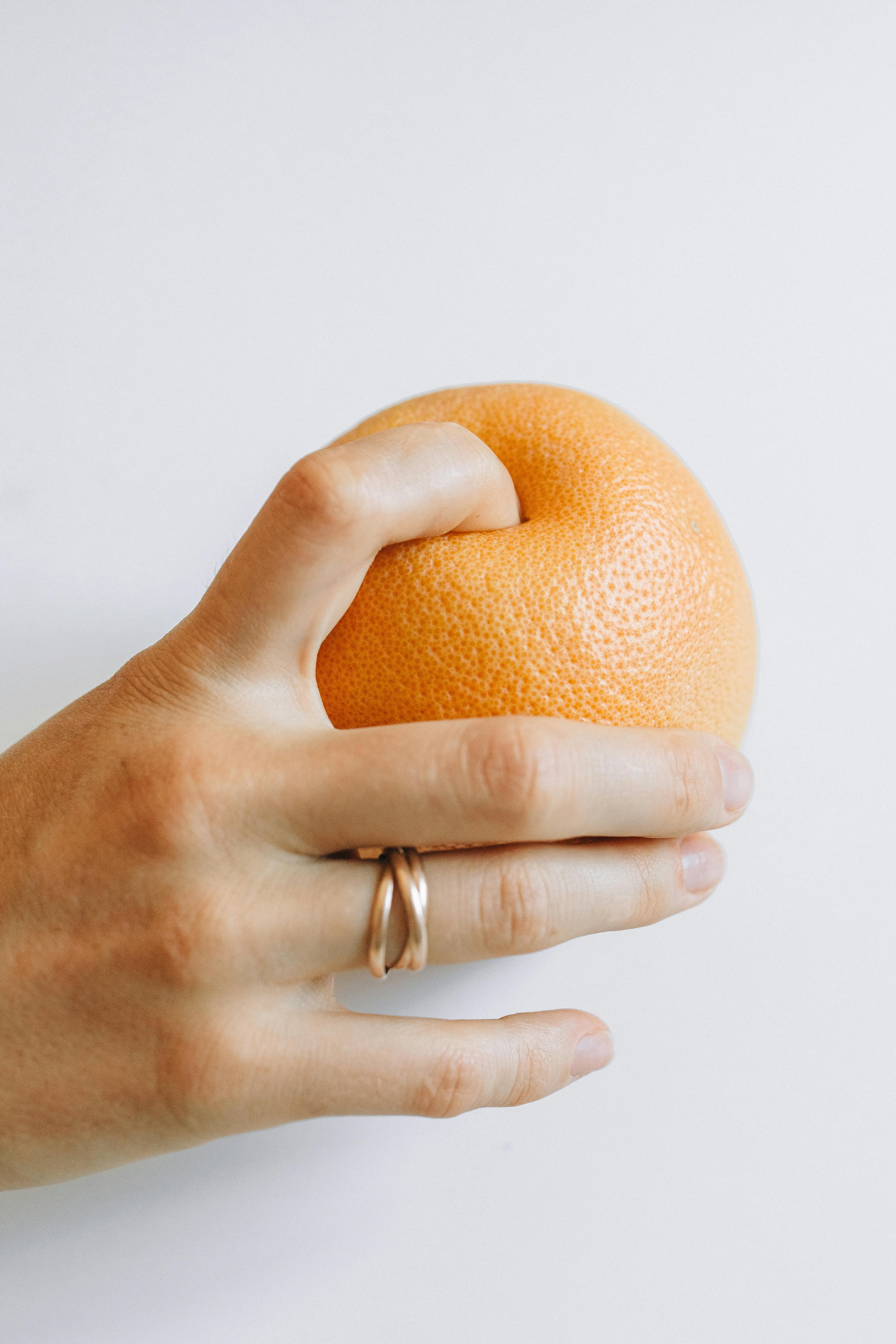 person holding orange fruit