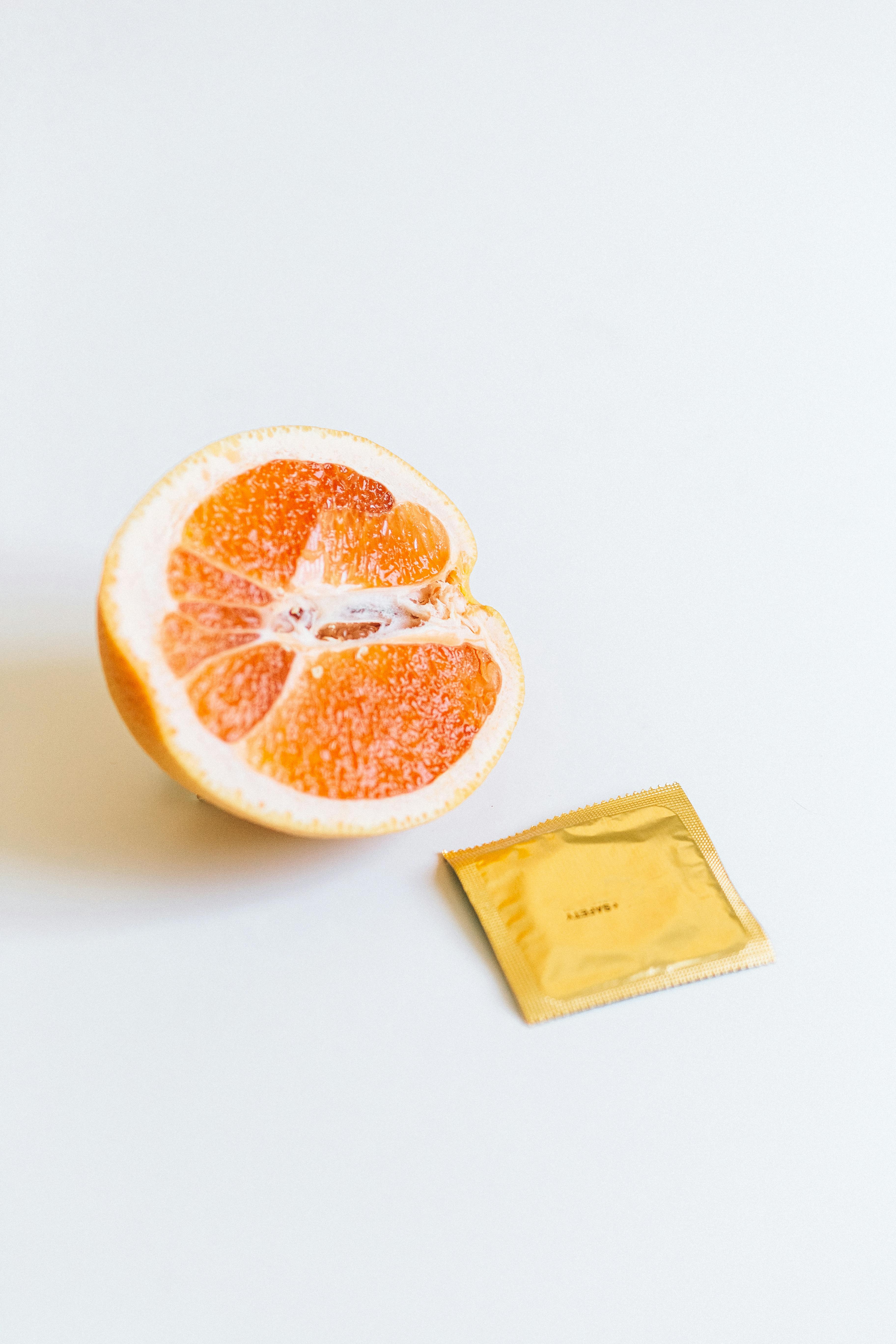 condom next to orange fruit