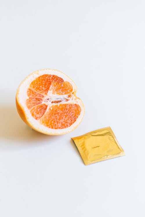 Condom Next to Orange Fruit