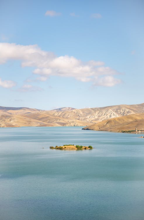 Picturesque scenery of tranquil blue lake located on hilly terrain on fair weather