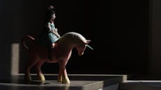 A Figurine of a Girl Riding and a Unicorn