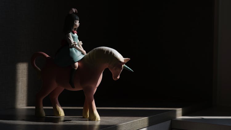 
A Figurine Of A Girl Riding And A Unicorn