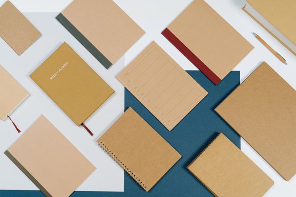 Flat lay of brown spiral notebooks and planners on a slate-blue ground — cottonbro studio on Pexels