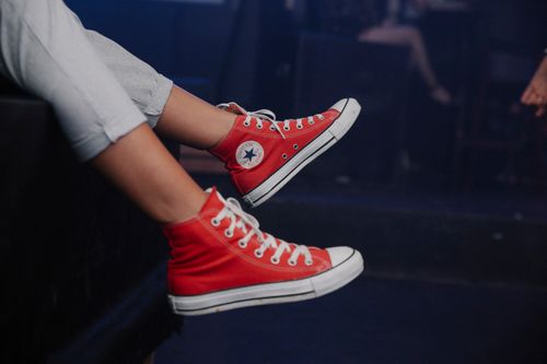 Free Relaxed shot of stylish red sneakers indoors, showcasing casual fashion and comfort. Stock Photo