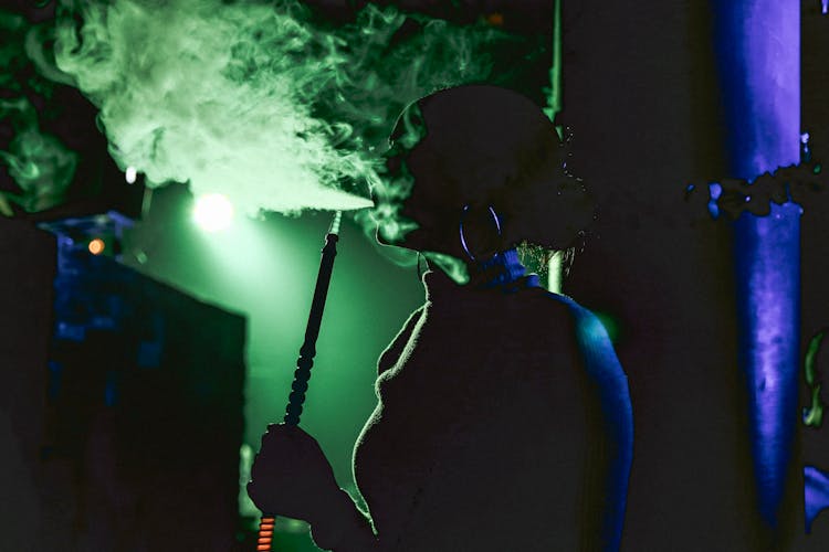 Woman Smoking Shisha In Bar 