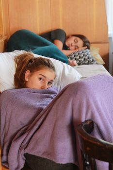 两名女子裹着毯子，在舒适的室内环境中放松身心，营造出宁静平静的氛围
