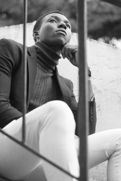 Free A stylish man in a turtleneck and blazer poses thoughtfully outdoors in black and white. Stock Photo