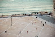 People walking on spacious city square on waterfront