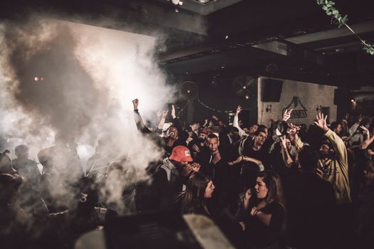 夜总会里热闹非凡，一大群人在变幻的灯光和烟雾中尽情跳舞