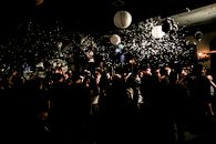 People Standing and Standing Under White Pendant Lamps
