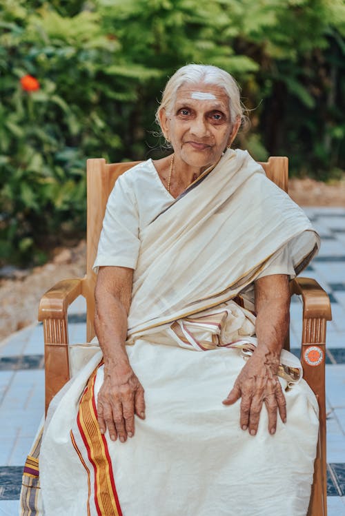Free Elderly Woman Sitting on a Wooden Chair Stock Photo