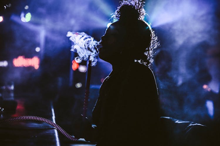 Silhouette Of A Person Smoking On Shisha