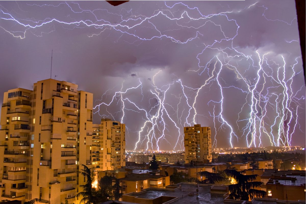 Skyline de Madrid al atardecer con tormenta eléctrica — riesgos urbanos de emergencia en la capital