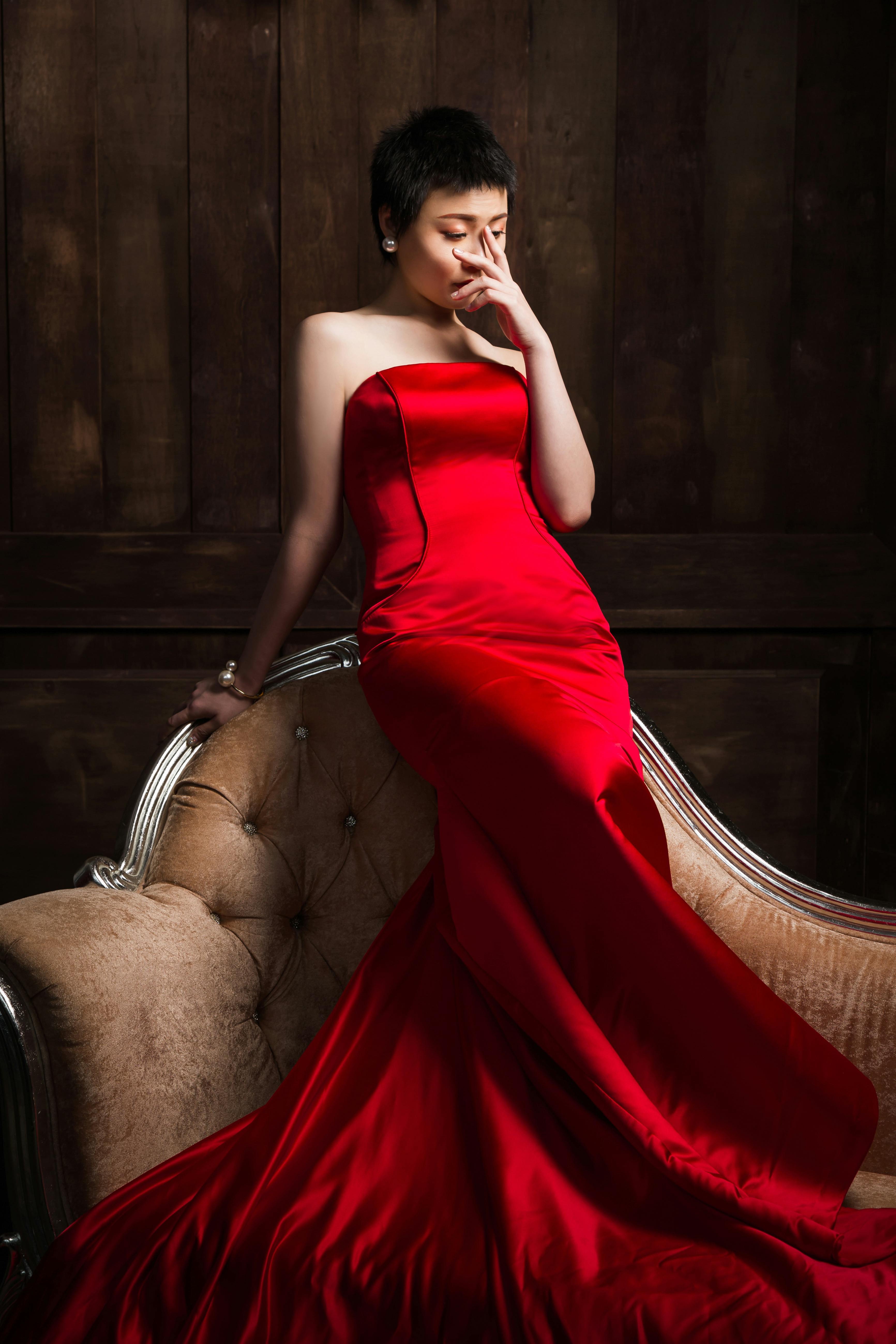 elegant dreamy asian woman in red dress on couch