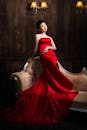 Elegant Asian woman in red dress on sofa