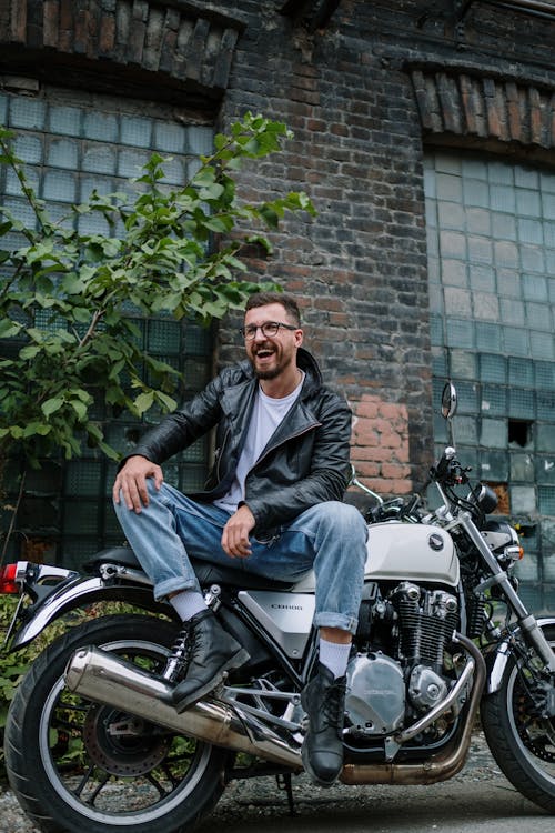 Smiling Bike in Leather Jacket Sitting on Motorcycle