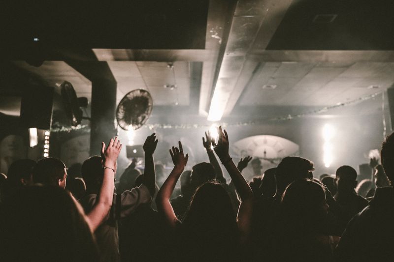Crowd dancing with raised arms at a club night — Maor Attias on Pexels