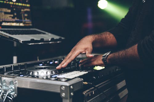 Person Playing Music Using Laptop and Dj Mixer