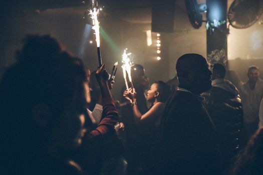 夜总会派对上，人们手持烟花，烟雾弥漫