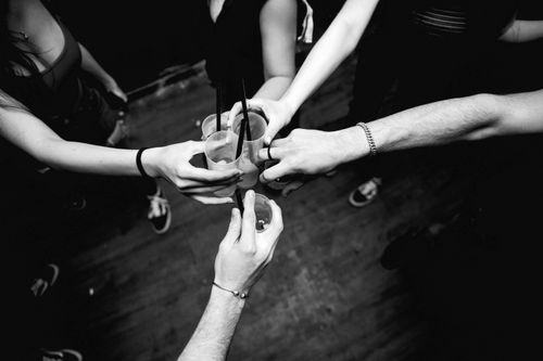 Free Black and white image of friends celebrating with drinks in a lively setting. Stock Photo