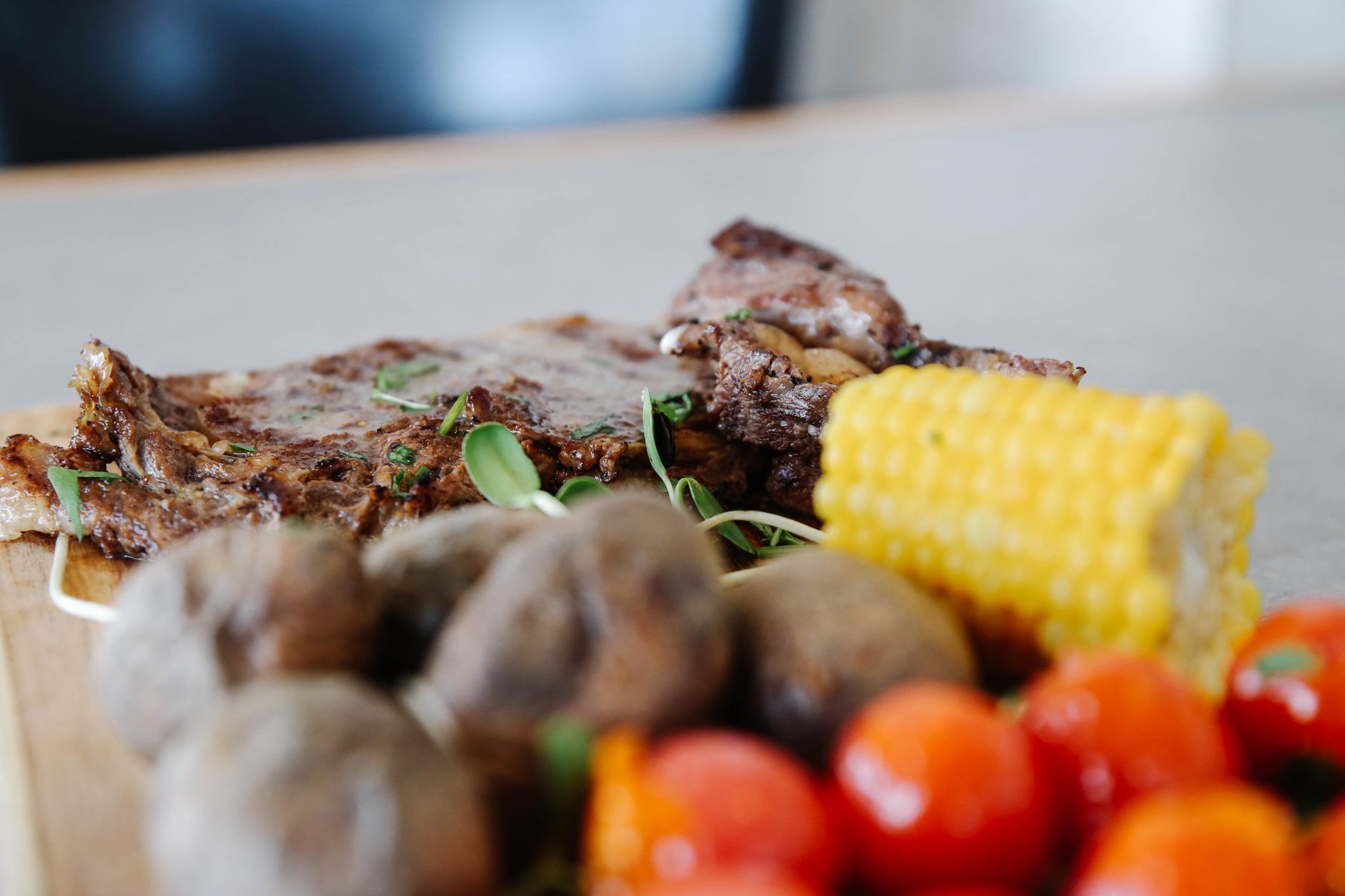 Grilled steak slices with fresh rosemary on wooden board