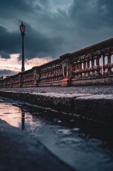 A dramatic view of a historic bridge at dusk in Minas Gerais, Brazil, reflecting a moody atmosphere.