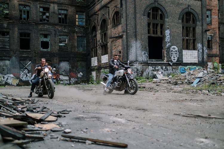 People Riding Motorcycles Near An Abandoned Building