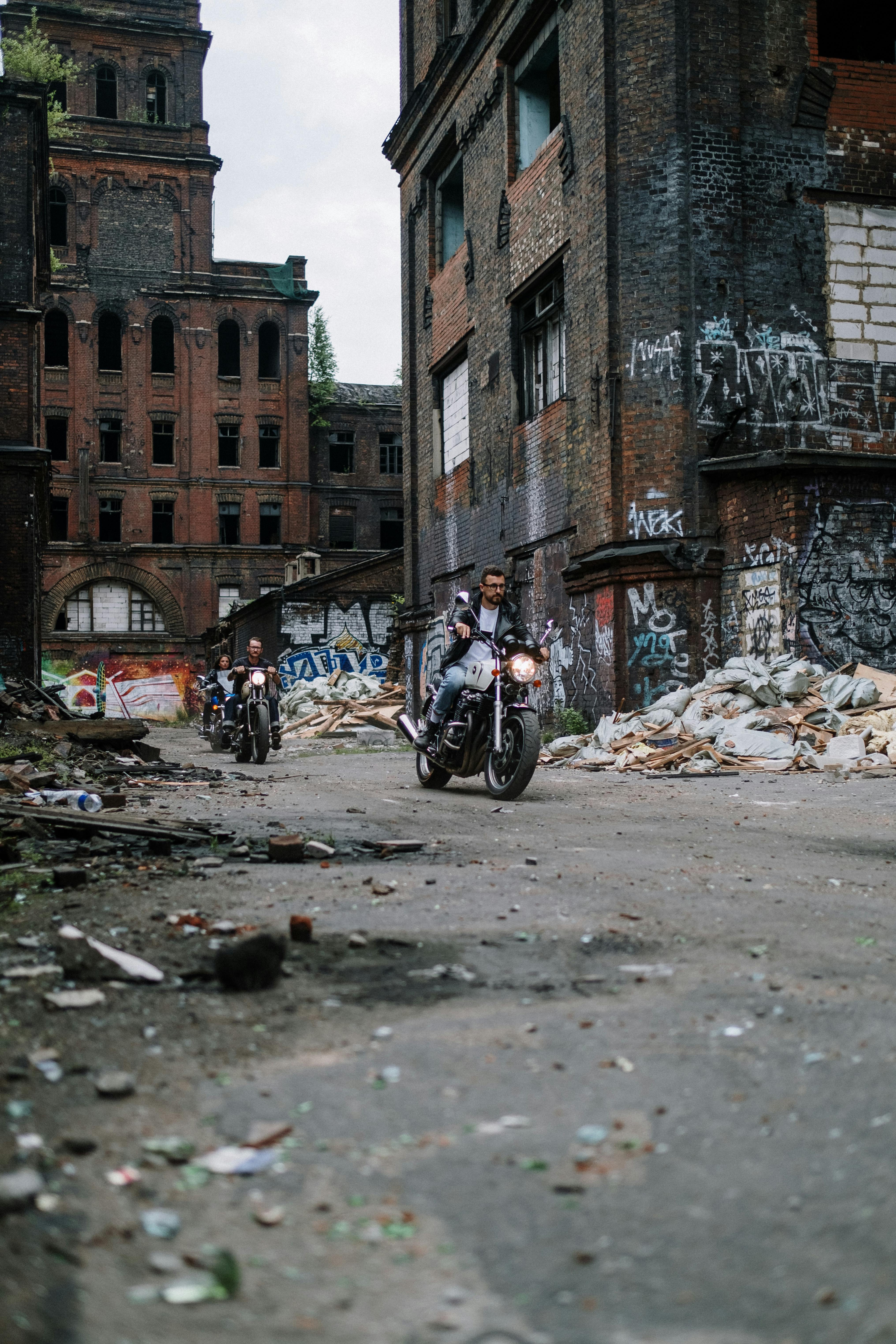 man in black jacket riding motorcycle near brown concrete building