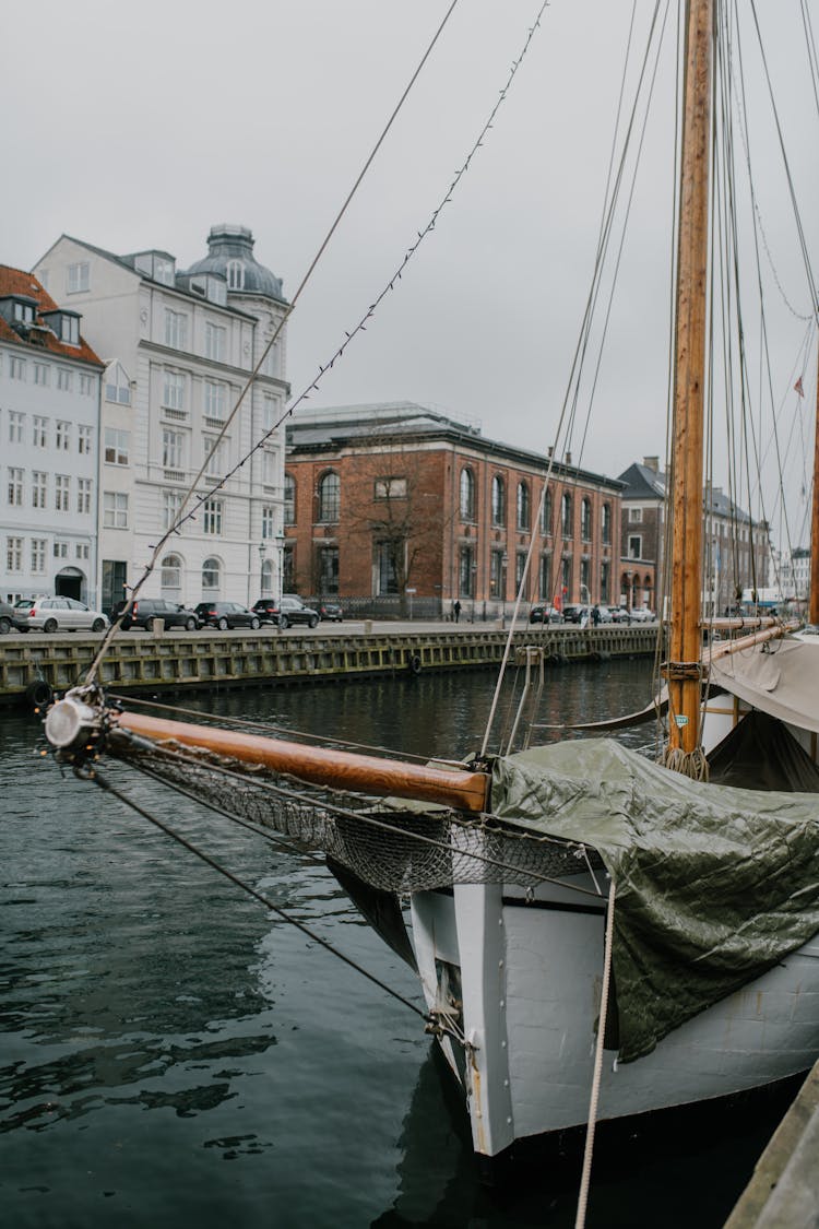 White And Brown Boat On Water Near Buildings