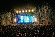 音乐会现场气氛热烈，舞台灯光璀璨，人群在夜晚中尽情享受