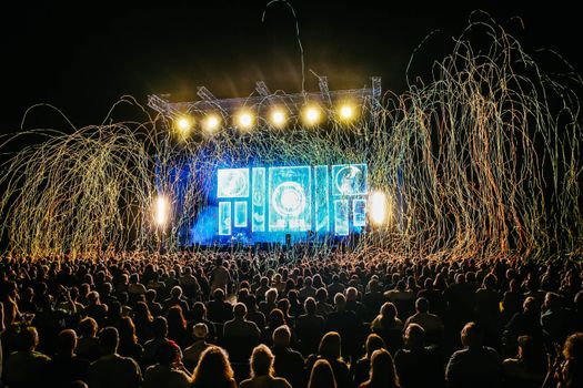 Dynamic live music concert with vibrant stage lights and a lively crowd enjoying the night.