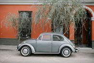 Blue Sedan Parked Beside Brown Concrete Wall