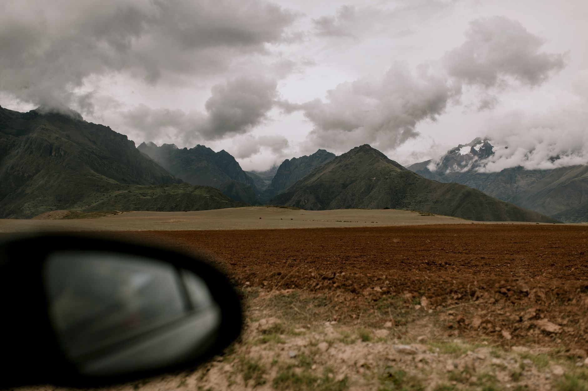 Explore the breathtaking Andes mountains in Cusco, Peru with dramatic skies and rugged terrain.