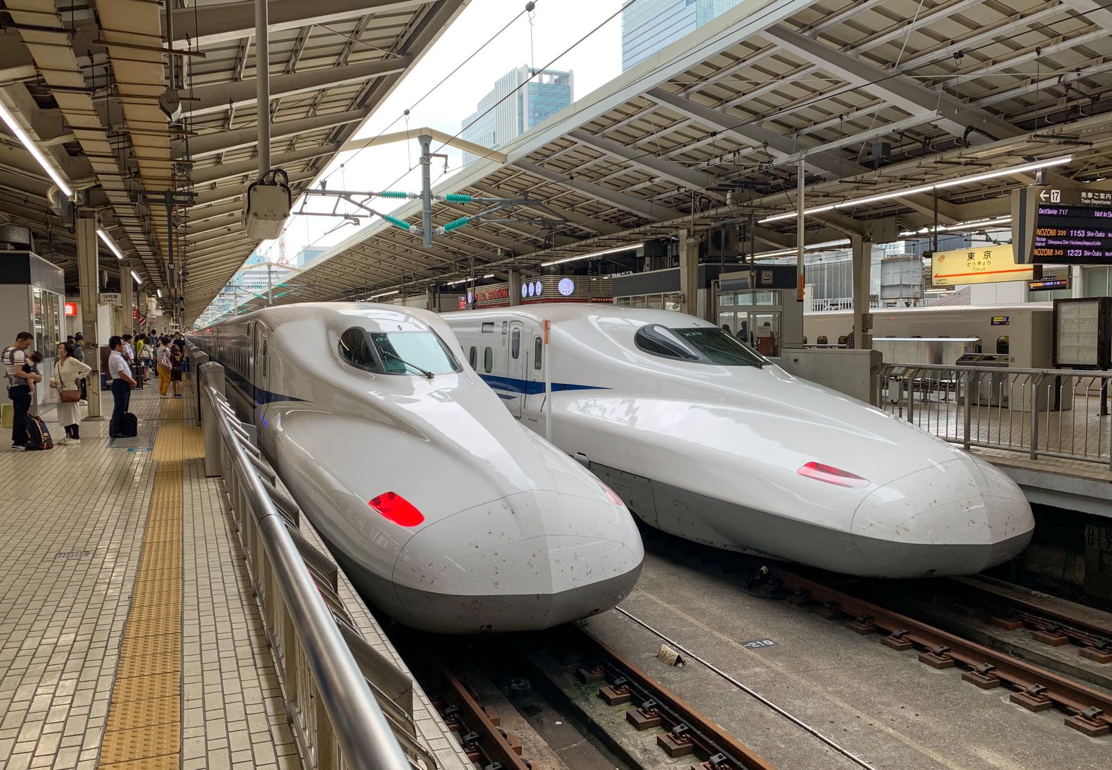 Two white Shinkansen bullet trains at a Tokyo station platform