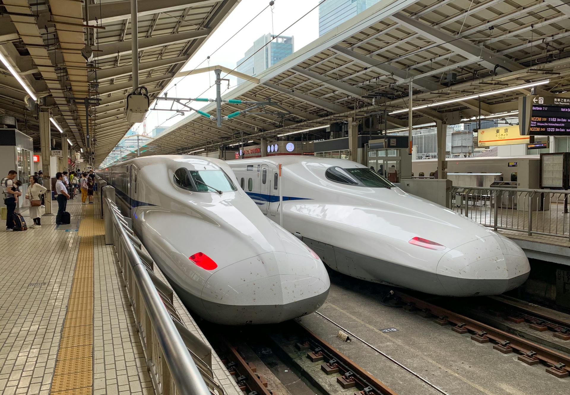 Two sleek shinkansen trains at Tokyo Station, Japan, waiting for passengers.