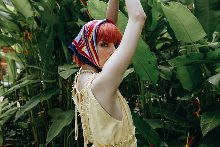 Enigmatic Woman Standing With Arms Raised In Tropical Forest