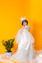 A Young Girl in White Gown Posing in the Studio