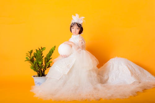 Woman in White Wedding Dress Sitting on White Textile