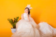Girl in White Dress Sitting Beside a Plant