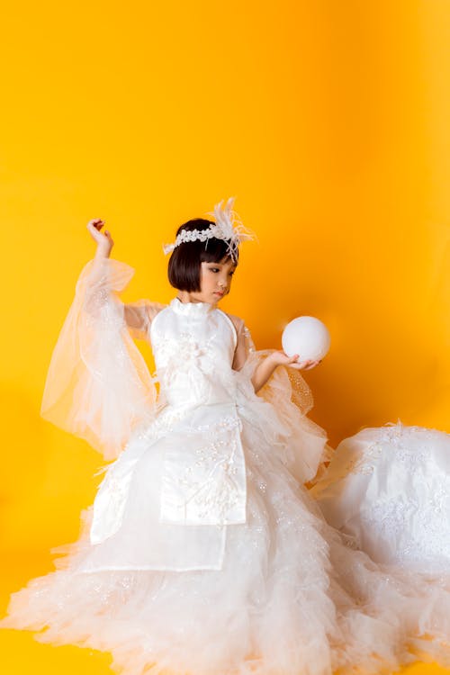 A Girl in Fairy Costume Holding a White Ball