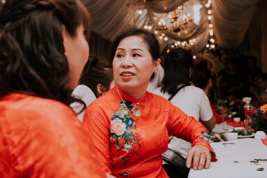 一名身穿鲜艳传统服装的女子，正在参加室内文化庆祝活动