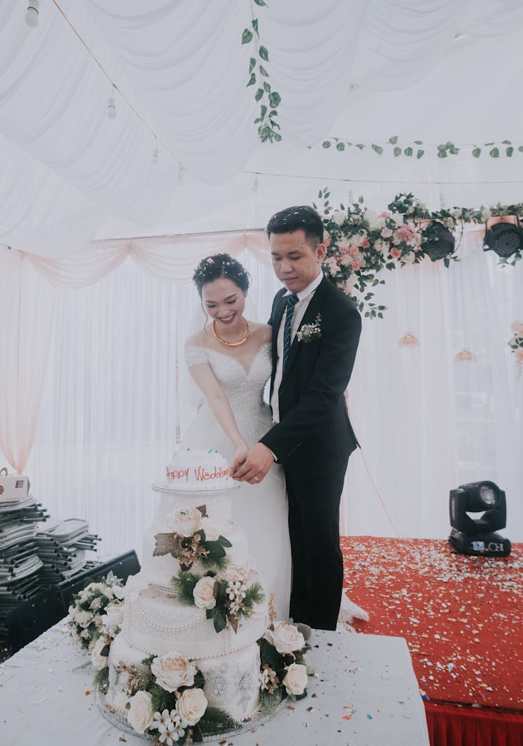 Happy Newlyweds Cutting Wedding Cake