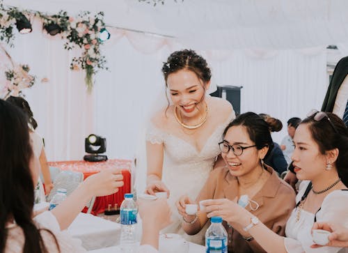 Happy bride with girlfriends clinking with alcohol