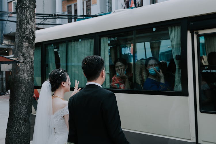 Happy Newlyweds Saying Farewell To Wedding Guests