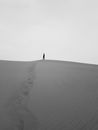 Person Walking in Desert Leaving Footprints Behind