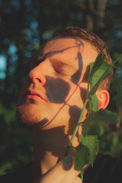 Free Relaxed man with eyes closed standing in lush forest Stock Photo