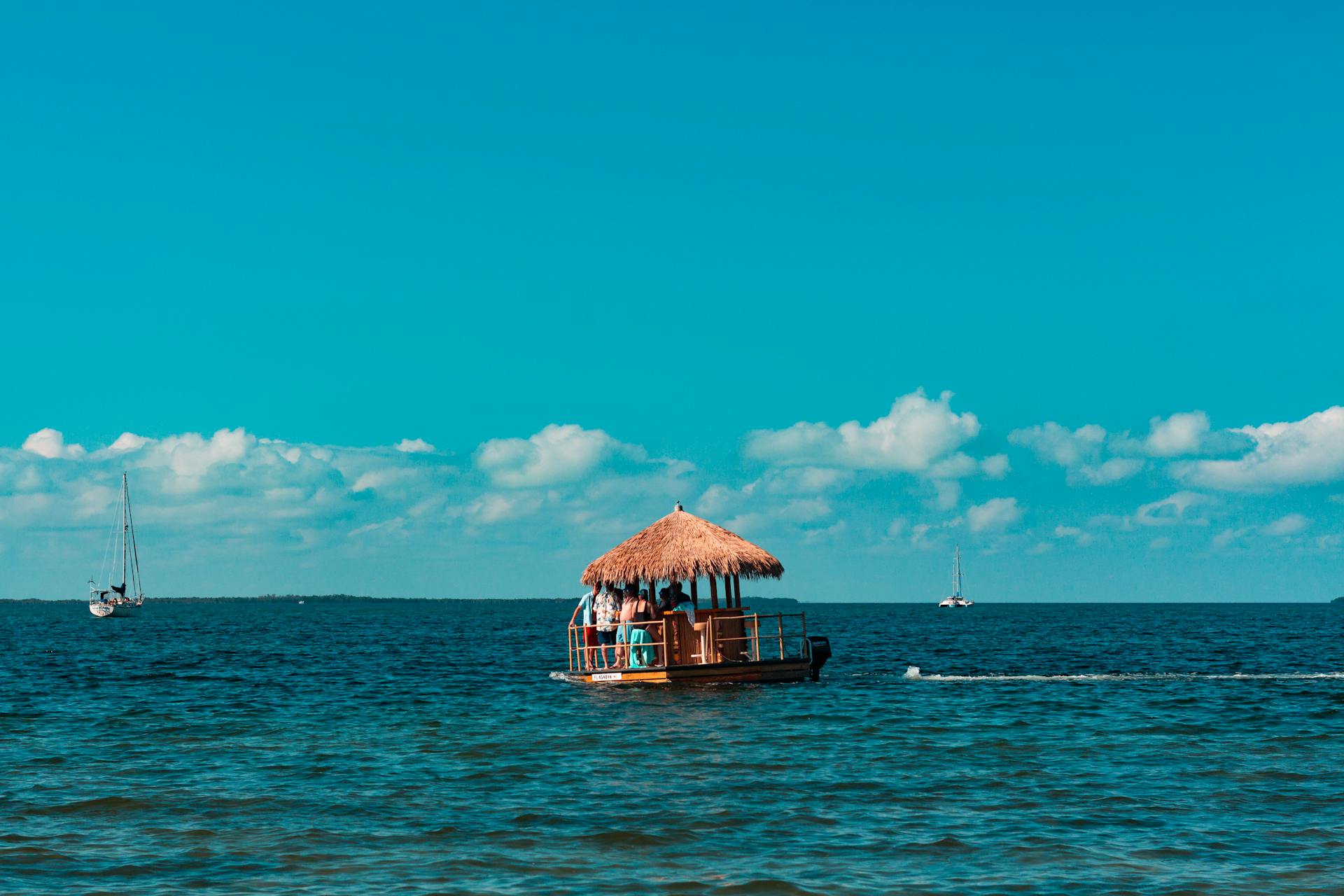 Charming floating tiki hut on azure Key West waters under a bright summer sky.