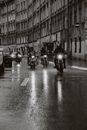 一群摩托车手在雨中穿越城市街道，展现自由与冒险