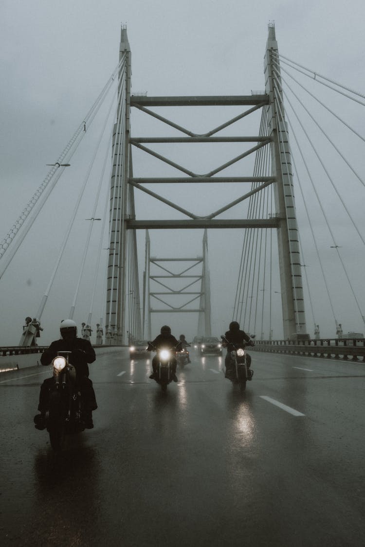 Motorcycle Riders Passing A Bridge